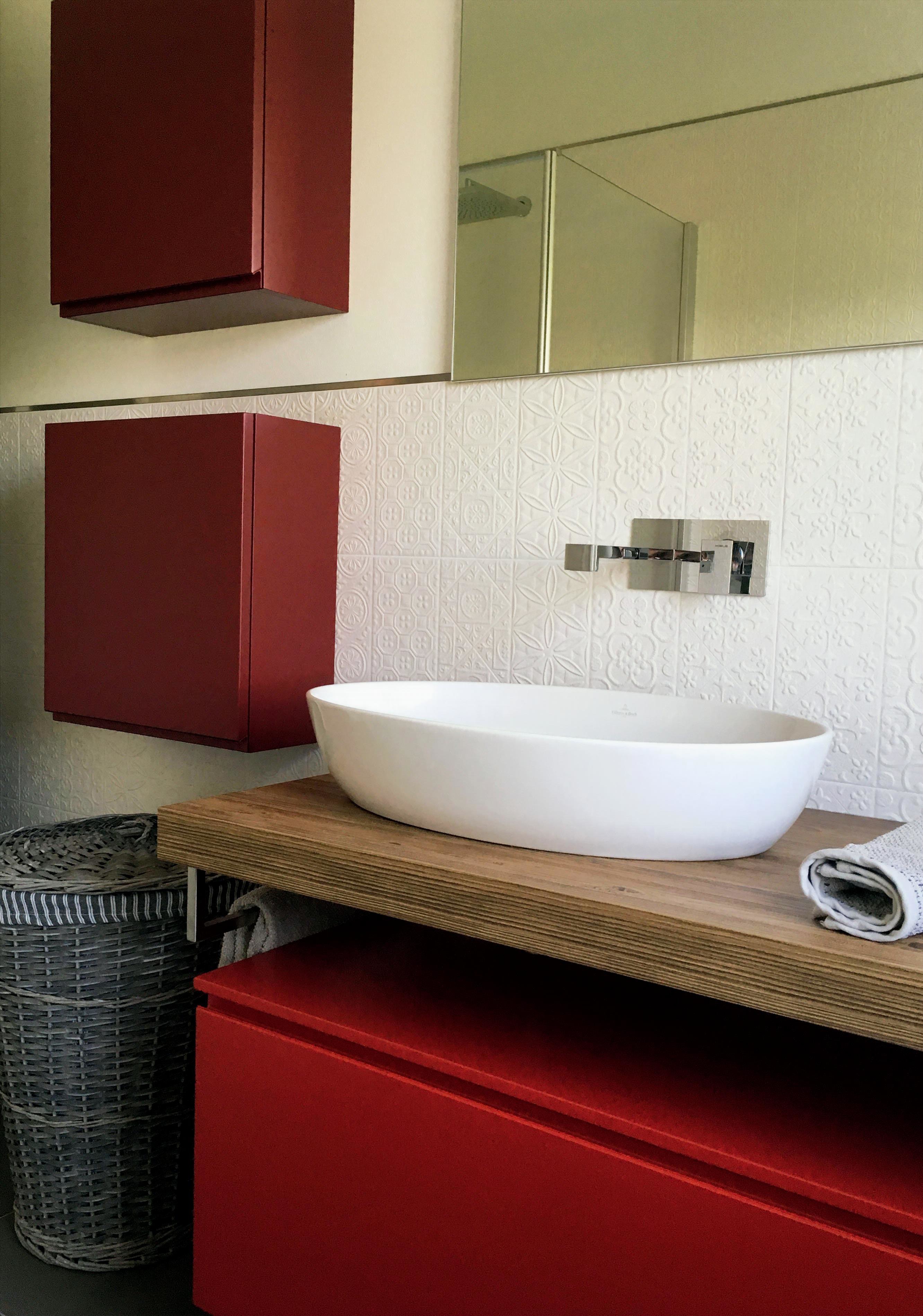 bagno con lavabo d'appoggio e mobili rossi