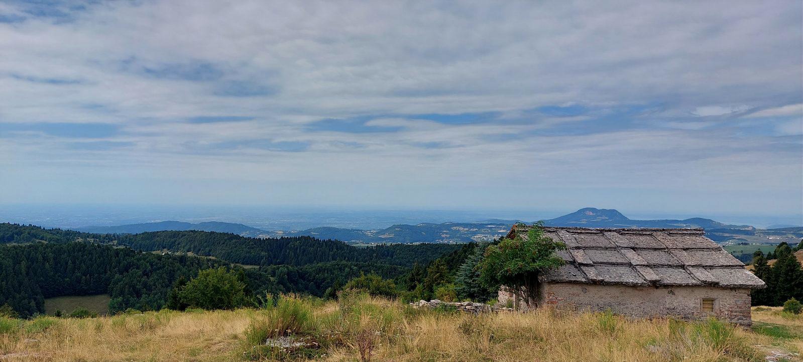 rifugio in pietra con tetto in lose su un altopiano panoramico
